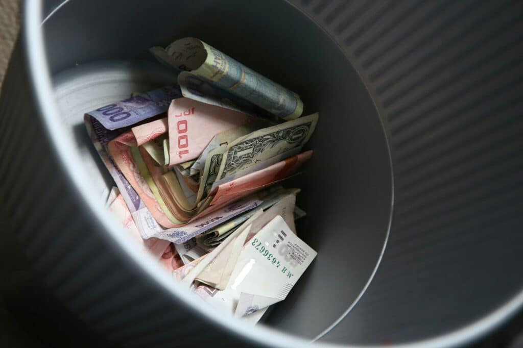 Bunch of paper bills with different currencies in a bin